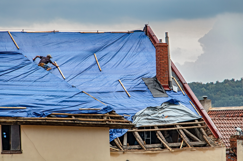 damaged roof with emergency roof tarp